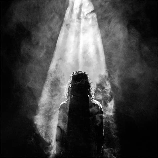 Black and white image of a person's silhouette with smoky background